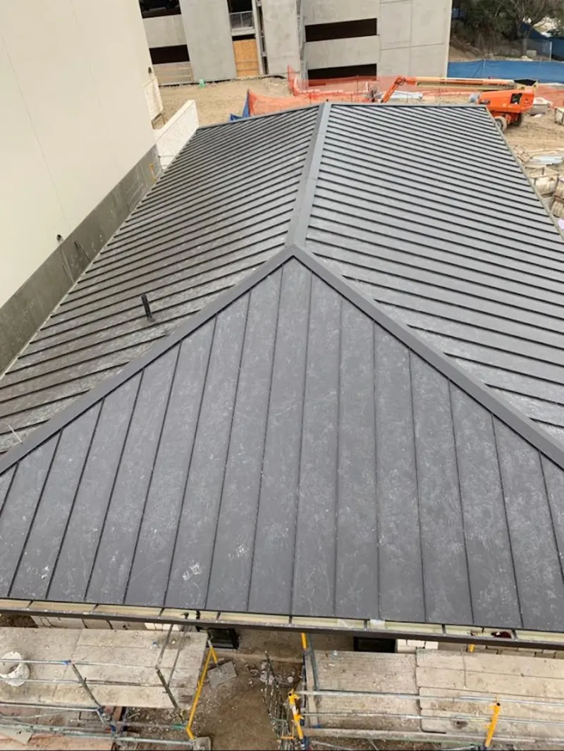 Commercial metal roof construction with crane equipment in Springfield